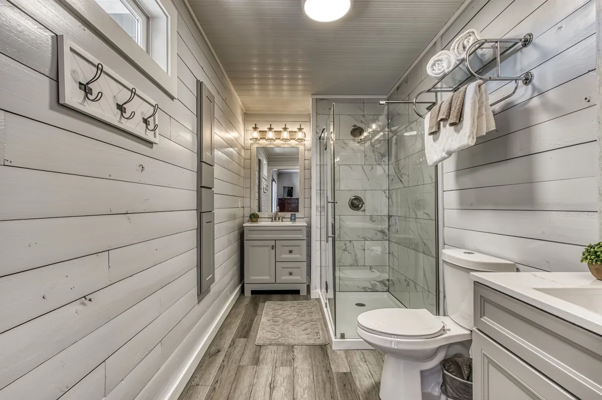 A modern, spa-like bathroom with a glass shower, vanity with sink, and a neatly arranged towel rack. The space offers a calming atmosphere, perfect for unwinding with a refreshing shower or bath after a day of hiking or exploring.