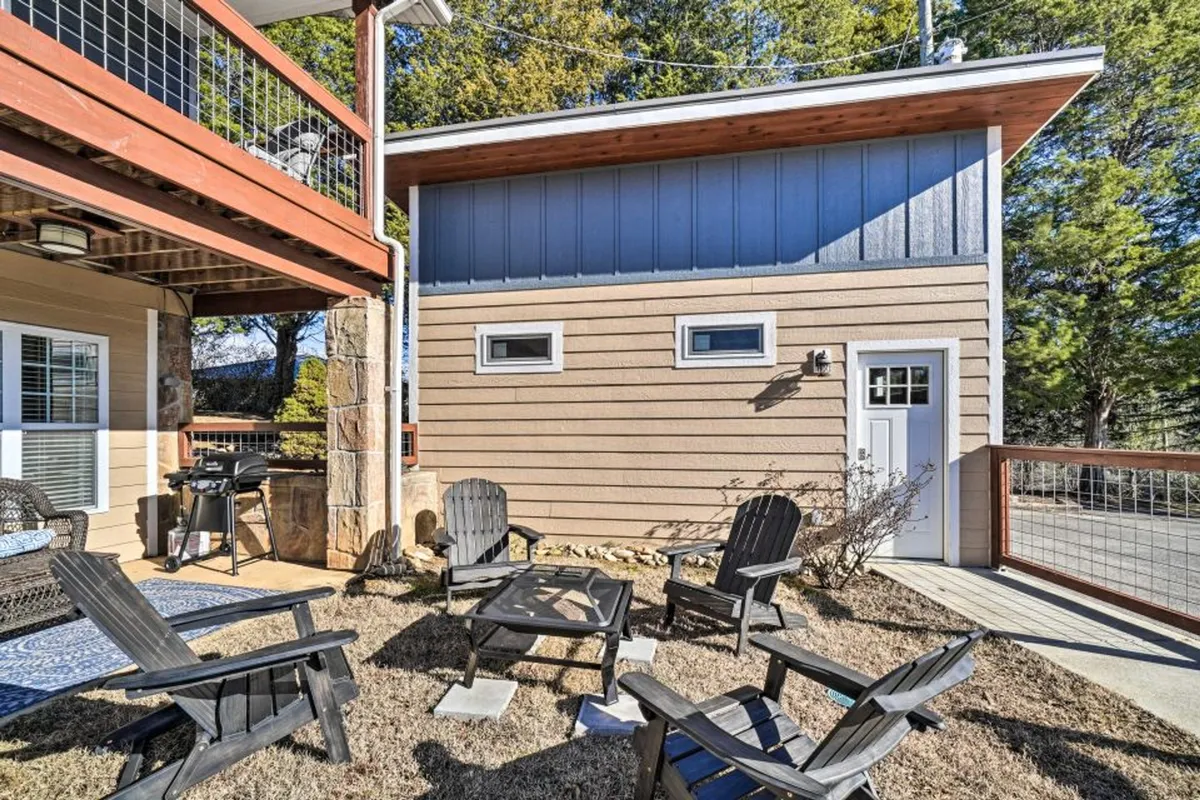 An inviting outdoor seating area with comfortable chairs and a grill set against the exterior wall of the building. The space hints at barbecues, social gatherings, and relaxation under the sun or stars, encouraging guests to make the most of the outdoors even while at home.